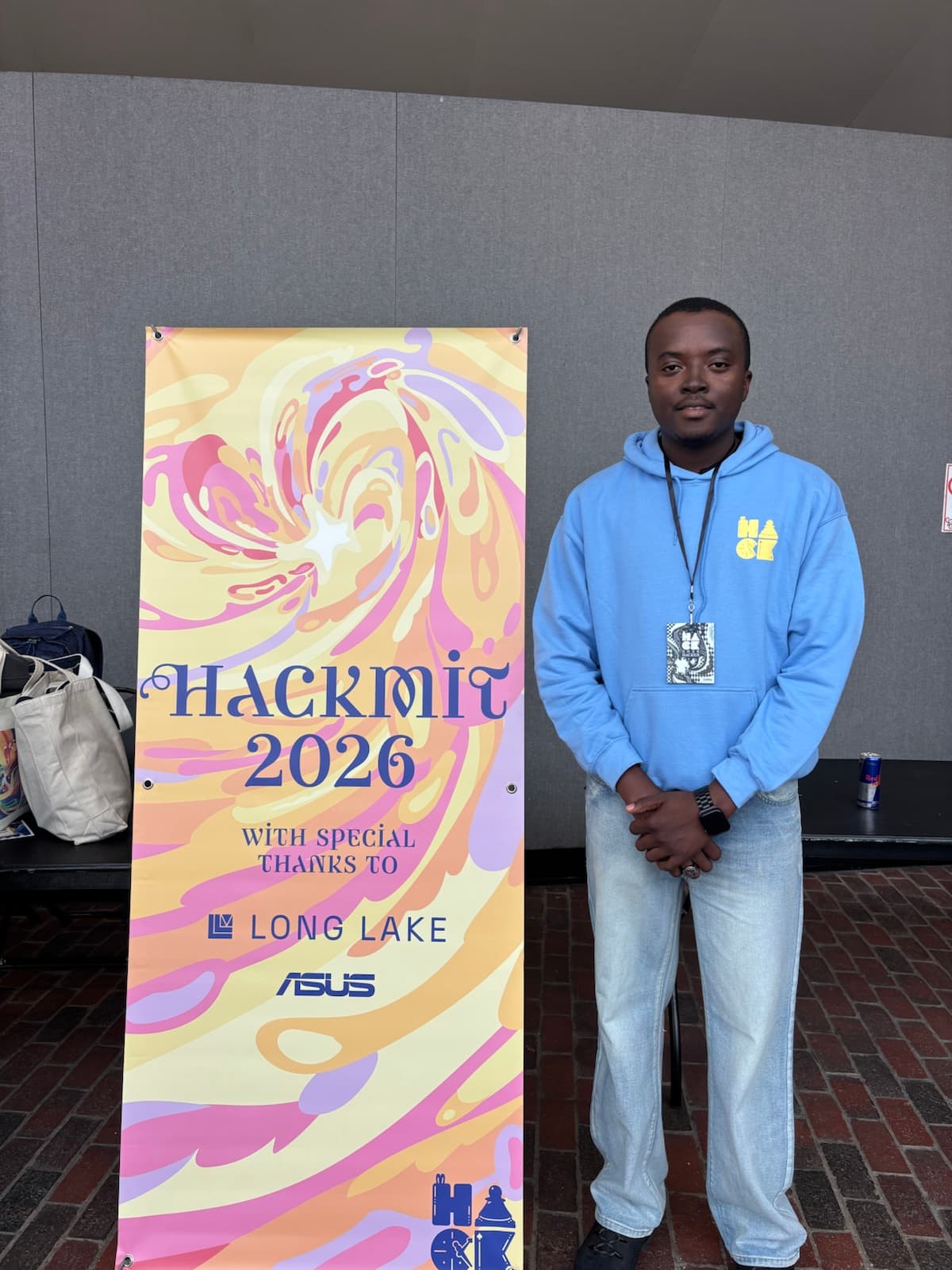 Eugene Lotsu standing beside the HackMIT 2026 banner
